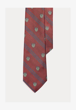 Gravata vermelha com riscas diagonais, apresentando pequenos padrões de brasão em azul e verde. Feita de tecido texturizado com extremidade pontiaguda.