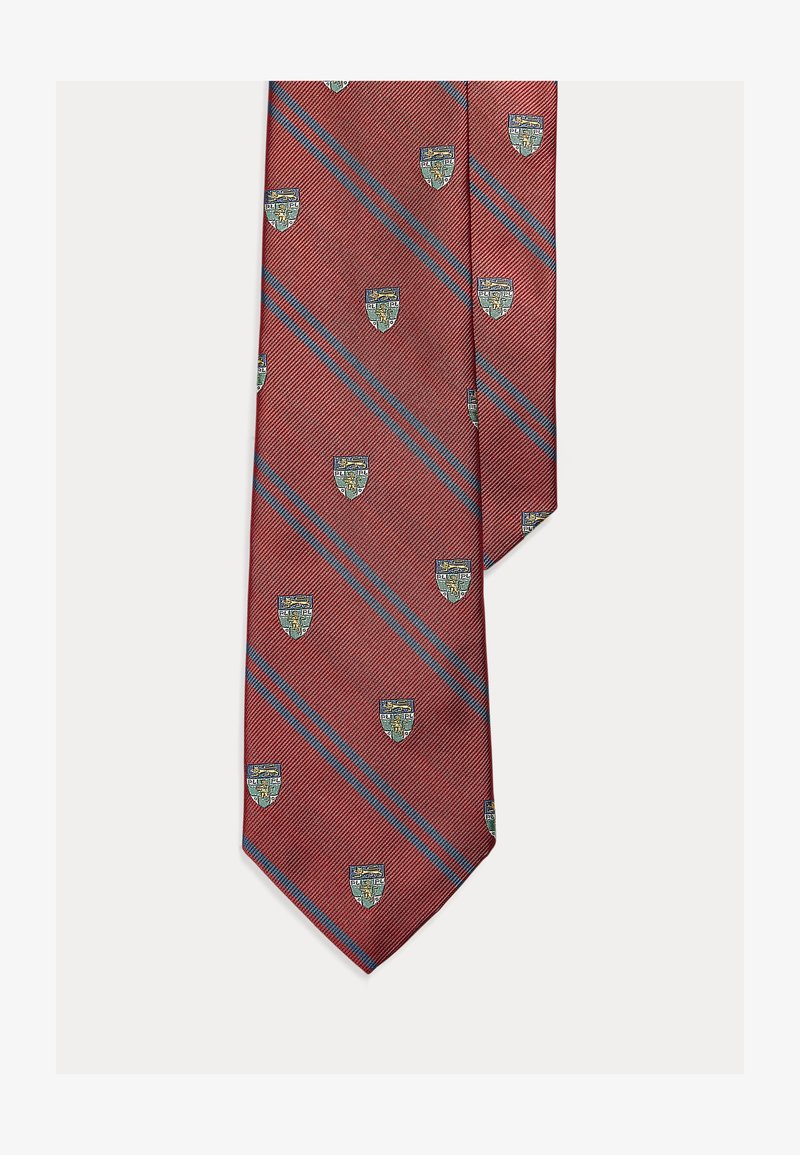 Gravata vermelha com riscas diagonais, apresentando pequenos padrões de brasão em azul e verde. Feita de tecido texturizado com extremidade pontiaguda.