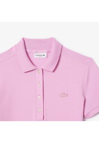 Polo rosa realizzata in tessuto testurizzato, con colletto classico, tre bottoni e logo ricamato sul lato sinistro del petto.