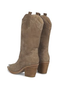 Botas de vaquero de ante marrón con punta afilada, diseño superior con scallops y un tacón de madera apilado. Presenta una punta metálica.