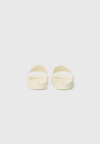 Lichtgele slidende sandalen met een gladde matte afwerking, voorzien van een open achterkant en brede banden voor comfort en gemak tijdens het dragen.