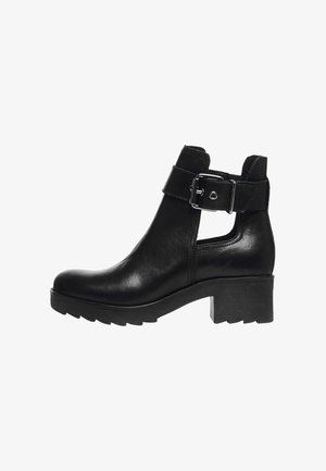 Bottines en cuir noir avec un talon épais, dotées d'une boucle latérale et d'un détail découpé. Fini lisse avec une semelle en caoutchouc durable.