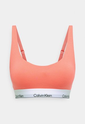 Korallszínű pamut bralette állítható pántokkal és fehér logo sávval, sima textúrával és egyszerű, lekerekített dizájnnal.