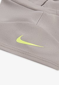 Gray textured fabric shorts featuring a prominent yellow Nike logo. The design includes pockets and a relaxed fit.