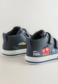 Jūras spēku ādas kurpes ar regulējamiem siksniņām, ar izšūtiem transportlīdzekļu motīviem: zila policijas mašīna, sarkans ugunsdzēsēju auto un dzeltena lidmašīna.