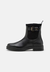 Stivali neri alla caviglia realizzati in pelle e suede, con zip laterale, dettagli con una fibbia dorada e una suola in gomma testurizzata.