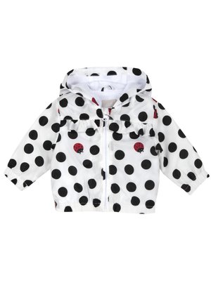 Giacca bianca per bambino piccolo con pois neri e stampe di coccinelle rosse, cappuccio, chiusura frontale con cerniera e polsini elasticizzati.