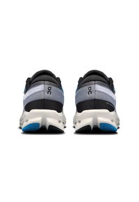 Zapatillas deportivas en gris y negro con acentos azules, presentan una parte superior texturizada, suela acolchada y una forma única de la suela exterior para mayor estabilidad.