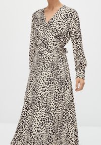 Robe portefeuille à imprimé léopard en tissu beige et noir. Manches longues, col en V, taille cintrée et jupe fluide à la texture douce.