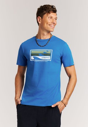 Blauw katoenen T-shirt met een rechthoekige afbeelding van groene en blauwe golfpatronen en de tekst "PROTEST" in het wit. Korte mouwen, comfortabele pasvorm.