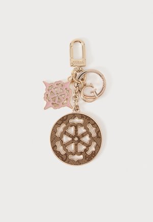 Porte-clés doré avec un grand charm circulaire, un charm carré rose et or, et un anneau avec la lettre G et la marque Guess.