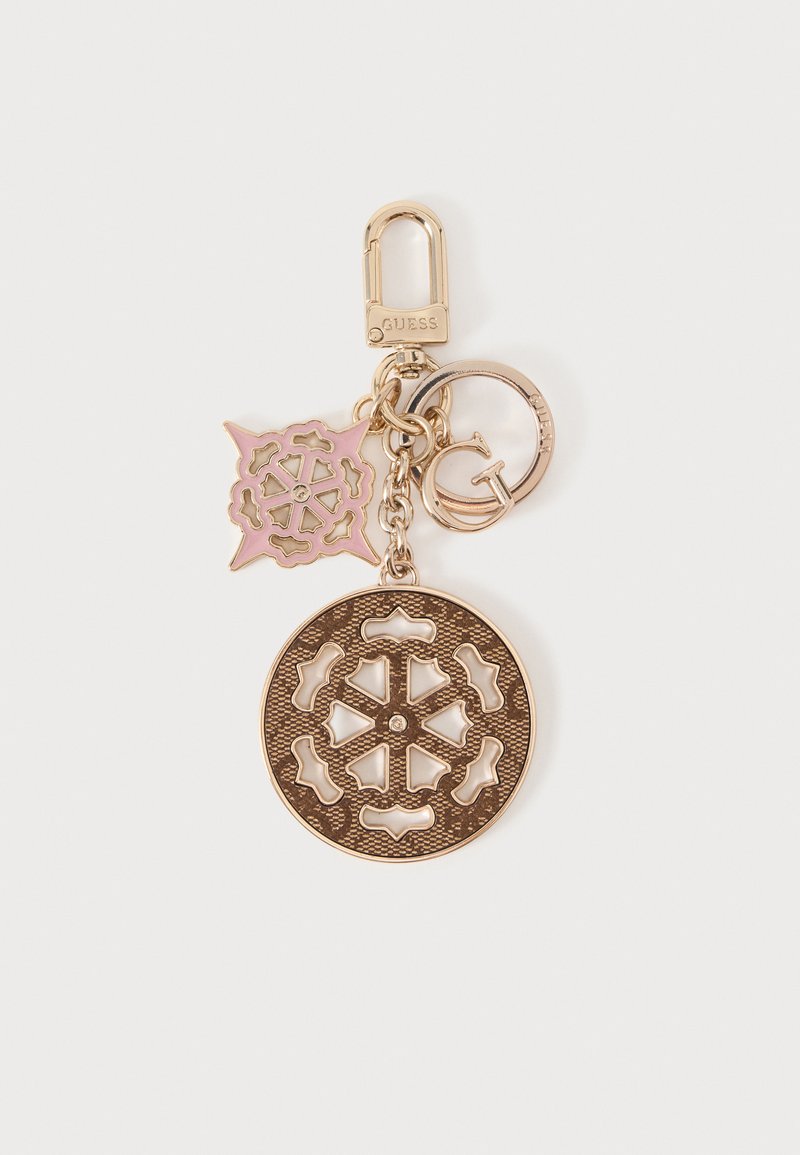Porte-clés doré avec un grand charm circulaire, un charm carré rose et or, et un anneau avec la lettre G et la marque Guess.