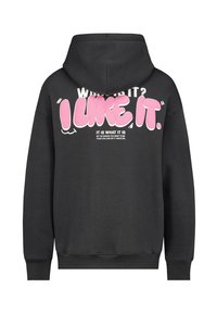 Schwarzer Hoodie mit einem großen rosa grafischen Text auf dem Rücken, der "ICH MAG ES" liest. Verfügt über eine Kängurutasche und gerippte Bündchen.
