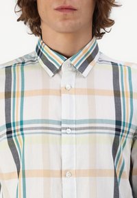 Chemise en carreaux légère présentant des rayures horizontales et verticales dans des tons de bleu, d'orange et de jaune ; col classique et fermeture à boutons sur le devant.