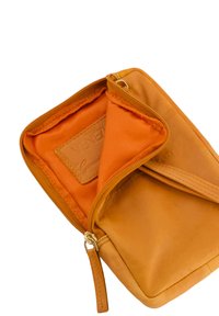 Orange læderpung med lynlås og en glat overflade. Indvendig foring er i orange stof med et brunlædermærke.