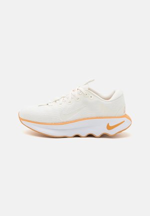 Biało-pomarańczowy sportowy but ze sznurowaniem, amortyzowaną podeszwą i logo Nike Swoosh z boku i na pięcie na białym tle.