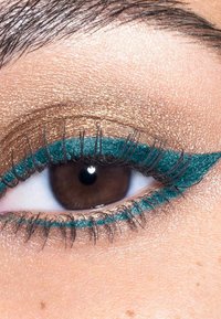 Brun øje med skinnende gyldent øjenskygge og tealfarvet vingeformet eyeliner på øvre og nedre vippe-linjer, lange øjenvipper synlige.