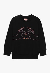 Felpa nera con maniche raglan, caratterizzata da mani ricamate che formano un cuore. Dettagli in rosa e arancione attorno alle mani.