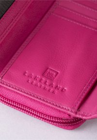 Pink leather wallet interior with textured surface, featuring card slots and embossed logo. Zipper along the edge adds functionality.