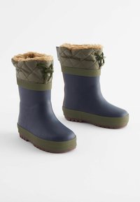 Bottes imperméables bleu marine avec un dessus matelassé vert olive, doublure douce couleur beige, lacet ajustable et semelles en caoutchouc texturé.