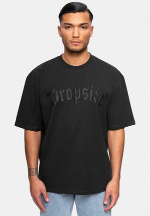 Black oversized t-shirt made of cotton, featuring a matte black textured "Dropsize" graphic on the front. Round neck and short sleeves.