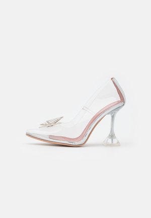 Chaussure à talon haut en PVC transparent avec bout pointu, talon aiguille argenté, et ornement décoratif papillon argenté à l'avant.