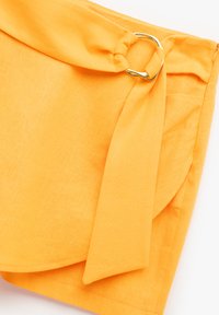 Gelbe Stoffshorts mit einer Schlaufen-Gürtel-Applikation und einem goldenen Ring, glatte Textur und lockere Passform mit abgerundetem Saum.
