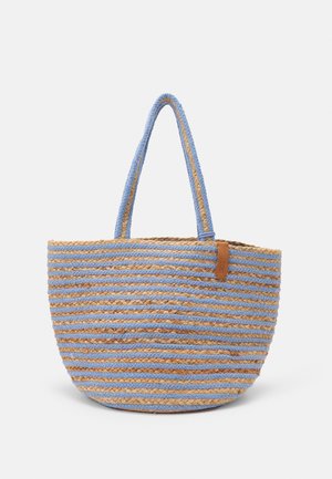 Sac fourre-tout tissé à la main avec des rayures horizontales bleues et marron naturel et deux longues anses sur un fond uni.