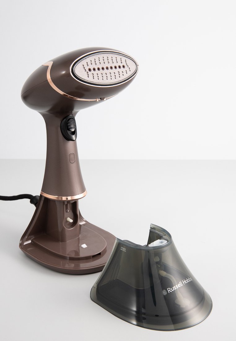 Vaporizador de prendas de mano marrón con una boquilla plateada y una base desmontable de color gris oscuro. Incluye un agarre texturizado y un botón de encendido/apagado.