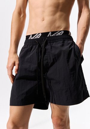 Sorte svøm Shorts lavet af let, struktureret stof. Har en elastisk talje med snøre og sidelommer.