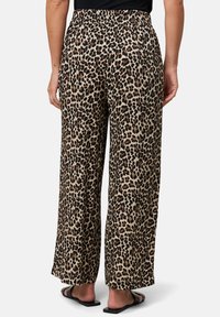 Brede pijpen, luipaardprint broek met een elastische tailleband, beige achtergrond en donkerbruine accenten, gemaakt van lichtgewicht stof.