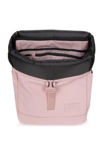 Pink synthetic bag with a fold-down top, black interior lining, multiple compartments, and a front buckle attachment. Smooth texture.