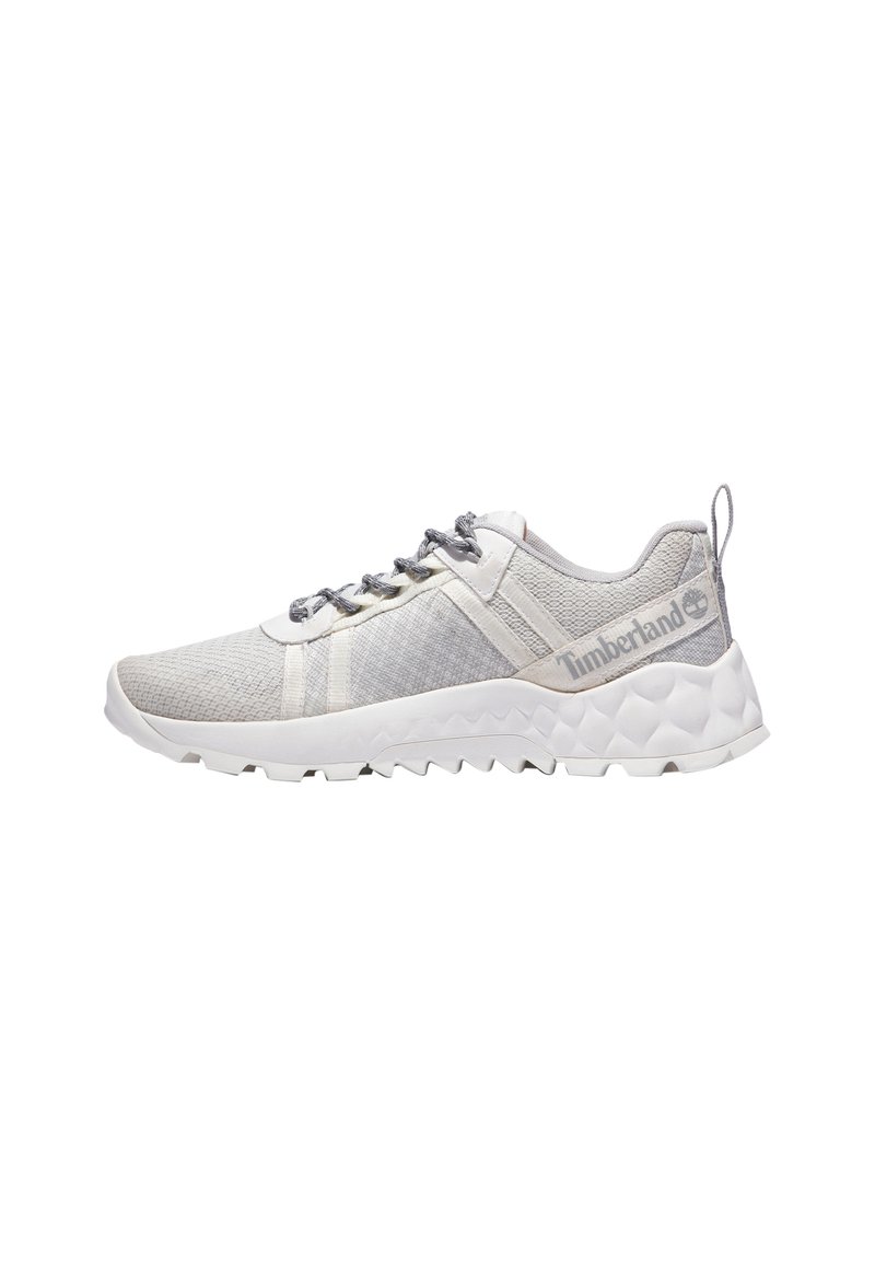 Zapatilla deportiva de malla gris con acentos blancos, superposiciones texturizadas, cordones prominentes y una suela rugosa y con patrón para tracción. Logotipo de Timberland visible.