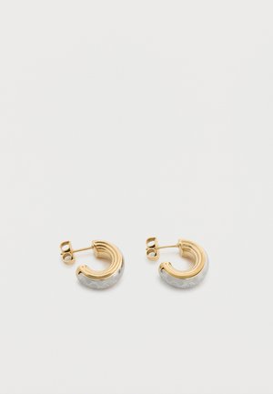 Petites boucles d'oreilles à tige en demi-anneau en or et en argent avec un bord extérieur texturé en argent sur un fond blanc.