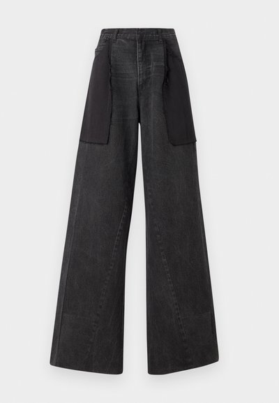 Jean à jambes larges en denim noir avec des panneaux de tissu noir sur les côtés, présentant une taille haute et des détails de couture visibles.