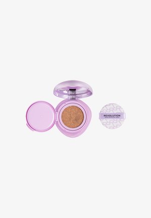 Poudre compacte lavande ouverte avec fond de teint coussin beige et applicateur rond séparé portant l’étiquette « Revolution » sur fond blanc.