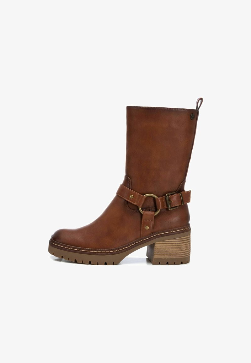 Bota de cuero marrón hasta la rodilla con un tacón apilado, que presenta una punta redonda, detalle de hebilla y suela texturada. Ajustes disponibles a través de la correa.