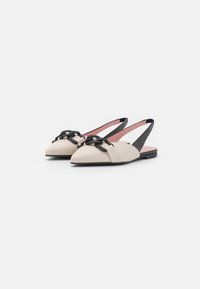 Bézs bőrből készült slingback cipők fekete láncdróttal, hegyes orral, lapos talppal és rózsaszín bélésével. Simává alakított textúra, minimalista dizájn.