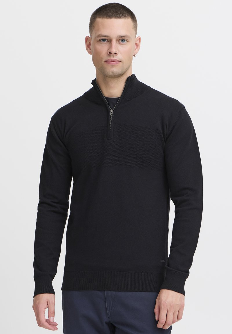 Maglione zip-up nero con maniche lunghe, caratterizzato da una texture a righe orizzontali sul petto e da polsini e orlo a coste.