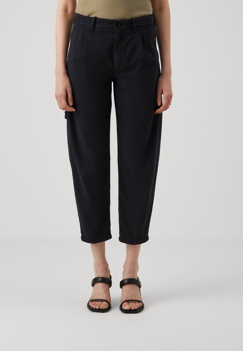 Pantalon bleu marine à coupe décontractée avec taille haute, chevilles effilées, poches avant et texture de tissu en coton lisse.