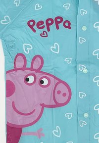 Children's raincoat in light blue, featuring a large pink pig character with a smiling face, surrounded by white hearts, and green buttons.