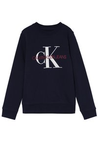 Sudadera azul marino hecha de una mezcla de algodón, con cuello redondo, puños acanalados y un gráfico en la parte frontal con "CALVIN KLEIN JEANS" en blanco y rojo contrastante.