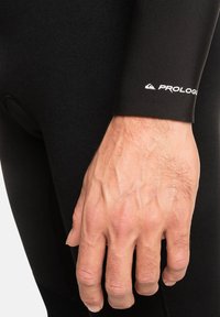 Zwart wetsuitmateriaal met een soepele textuur, voorzien van een Prologue-logo op de mouw, dat een aansluitend en gestroomlijnd ontwerp toont.