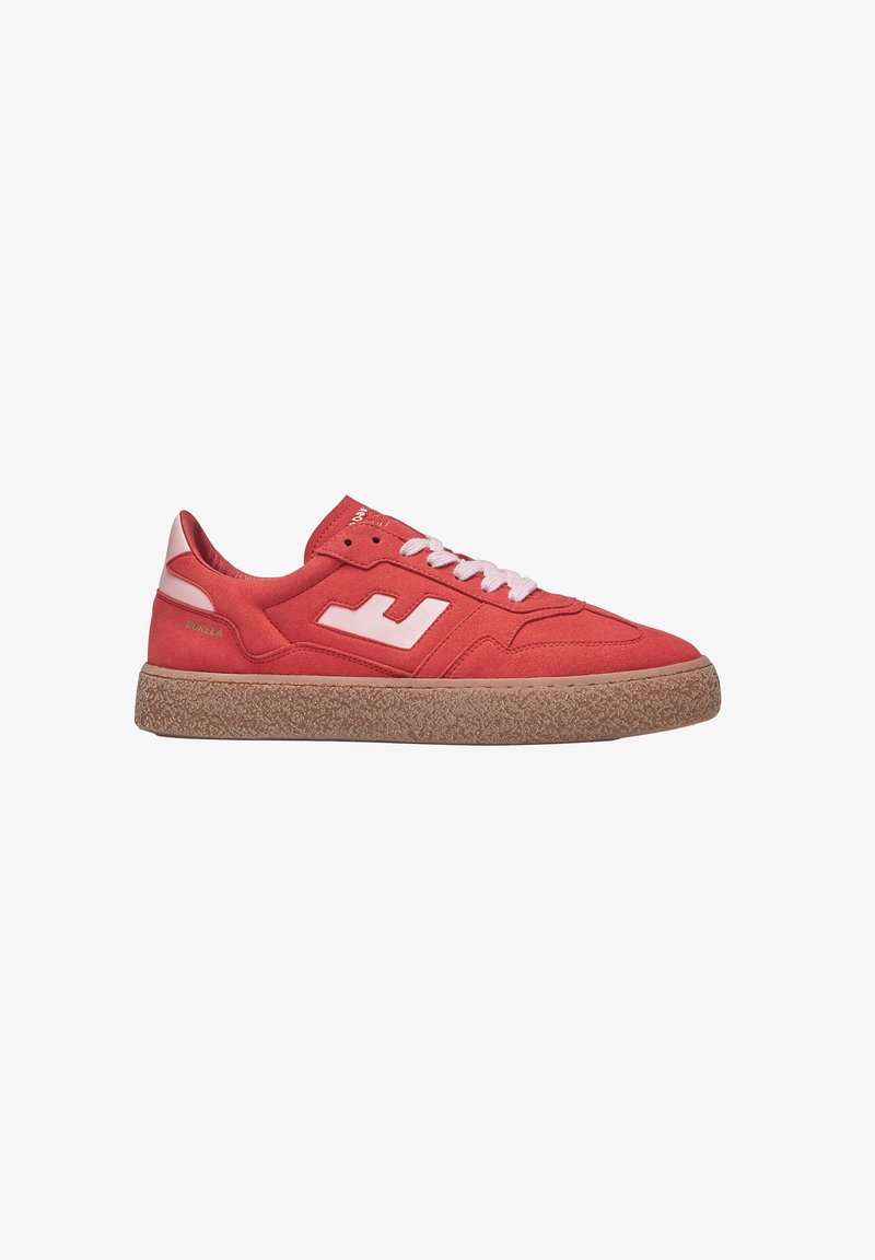 Baskets en toile rouge avec des accents blancs, bout rond, semelle en caoutchouc texturée et lacets contrastés. Présente un logo sur le côté.