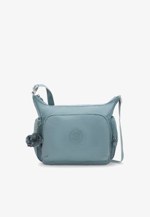 Hellblaues Umhängetasche mit vorderer Reißverschlusstasche, seitlichen Reißverschlüssen, verstellbarem Trageriemen und einem kleinen Plüsch-Schlüsselanhänger, der an einer Seite befestigt ist.