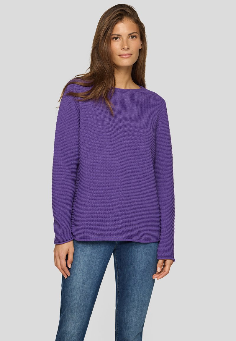 Lila strukturierter Pullover mit Rundhalsausschnitt und langen Ärmeln, kombiniert mit blauer Jeans. Verfügt über eine lockere Passform und ein geripptes Muster.