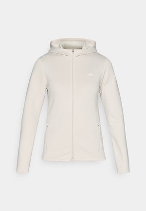 Lys beige zip-up hettegenser med hette, lange ermer og sidelommer. Glatt stoff med en subtil tekstur og en liten logo på brystet.