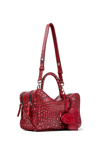 Sac à main en cuir rouge à texture crocodile avec doubles poignées, bandoulière amovible, fermetures éclair et étiquettes en cuir décoratives.