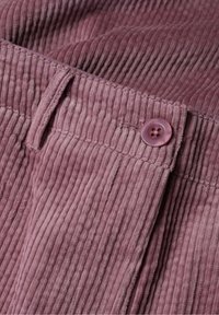 Pamučna tkanina u mekoj mauve boji s vertikalnim rebrima. Dugme za zatvaranje na struku. Glatka tekstura sa suptilnim sjajem. Čiste ivice i šavovi.