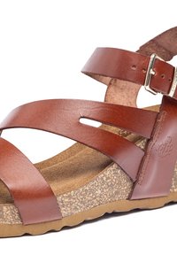 Sandalo in pelle marrone con cinturini incrociati e una fibbia. La soletta in sughero offre una texture, mentre la suola in gomma presenta un motivo antiscivolo.
